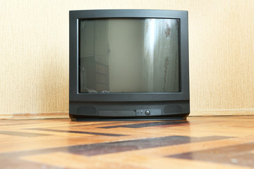 Vintage Television stands on a wooden parquet floor, old design in the house.