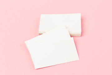 Fototapeta na wymiar white blank business cards on pink background in close-up