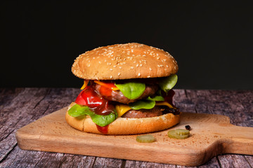 big fried cheeseburger on a dark background