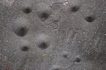 Shadow indents on dark gray sand abstract horizontal nature background pattern