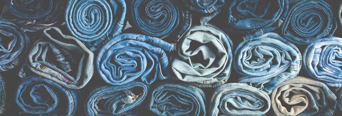 Stack of various shades blue jeans. Jeans stacked isolated on white background. Blue denim jeans...