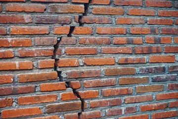 Brick wall with irregular crack from top to bottom