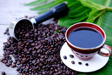 Coffee cup and coffee beans on wooden table background