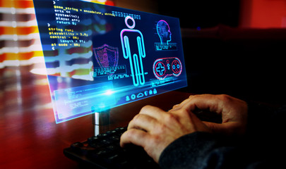 Man typing on keyboard with game creating on hologram screen