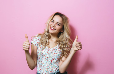 Close-up  of a blonde presents gestures over pink background