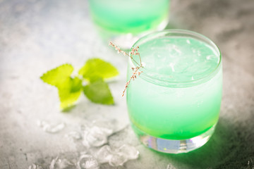 glass of cold drink with fresh mint leaves and ice cubes