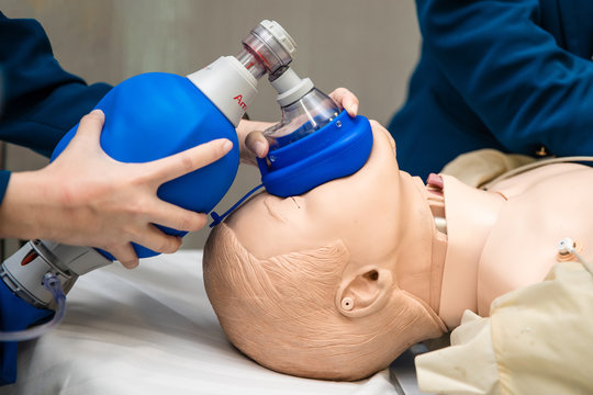 Hands holding a ambu bag on dummy patient, first aid training, CPR medical procedure