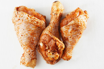 Raw drumsticks on white background. Chicken legs. Raw chicken marinated legs. Top view. Food Background. Cooking content. Uncooked meat. Meat shop concept.