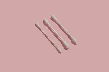 Different shape cotton swabs on pink background