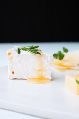 Fresh homemade cottage cheese of honey and rosemary on a dish and another portion of cheese plate in background. Healthy eat concept - breakfast with cottage cheese or ricotta with honey