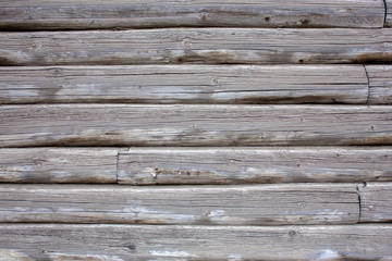 The wall of an old wooden house of logs. Natural wood, rough texture.
