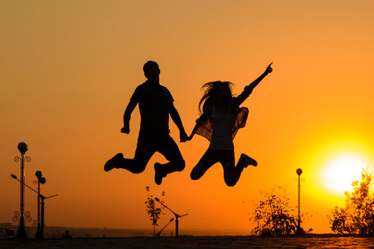 couple jumping in sunset
