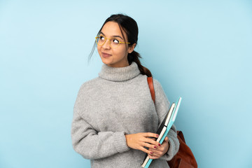 Young mixed race woman going to school isolated on blue background scheming something