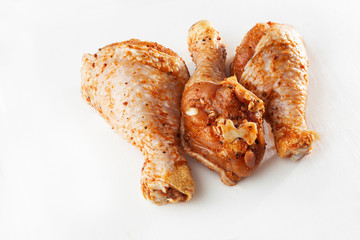 Raw drumsticks on white background. Chicken legs. Raw chicken marinated legs. Top view. Food Background. Cooking content. Uncooked meat. Meat shop concept.