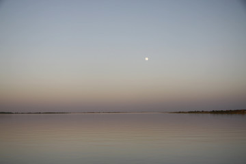 Malowniczy wschód księżyca w pełni na gładkim niebie nad spokojnymi wodami rzeki Niger - obrazy, fototapety, plakaty