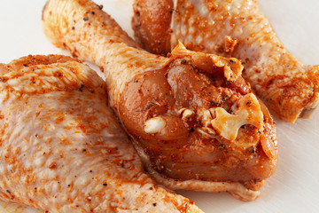 Raw drumsticks on white background. Chicken legs. Raw chicken marinated legs. Top view. Food Background. Cooking content. Uncooked meat. Meat shop concept.