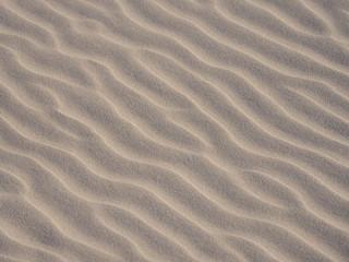 Closeup of yellow sand pattern of a beach in the summer. 
