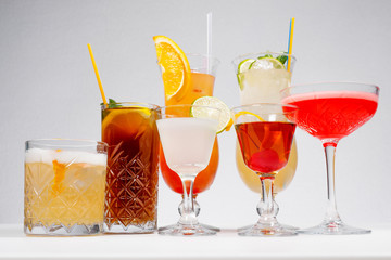 Glasses of tasty summer cocktails on white background