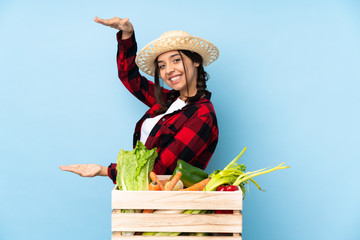 Young farmer Woman holding fresh vegetables in a wooden basket holding copyspace to insert an ad