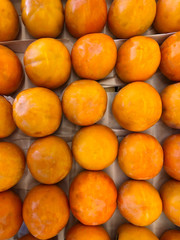 a lot of persimmons on the counter supermarket