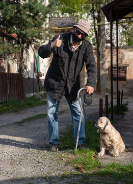 Senior Man In Protective Mask With A Cane Walking With A Dog