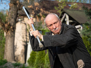 Elderly man threatening with a cane
