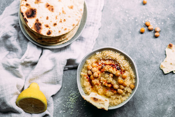 hummus in a plate on a table with corn tortillas