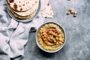 hummus in a plate on a table with corn tortillas