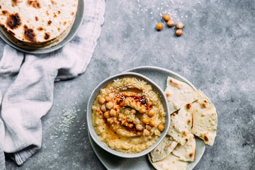 hummus in a plate on a table with corn tortillas