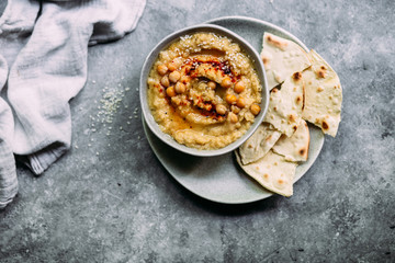 hummus in a plate on a table with corn tortillas