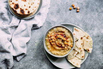 hummus in a plate on a table with corn tortillas