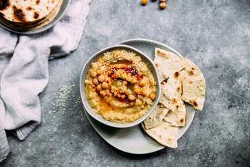 hummus in a plate on a table with corn tortillas