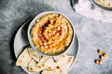 hummus in a plate on a table with corn tortillas