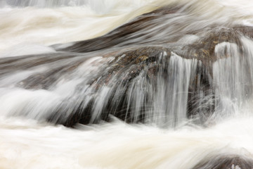 Fototapeta na wymiar Water of the Big Thompson River rushes over rocks within Rocky Mountain National Park, Colorado