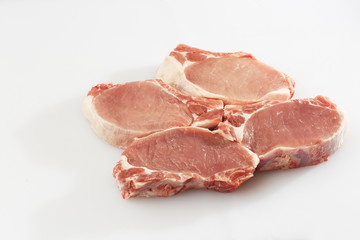 slices pork loin on a white background. Raw pork. Advertising for meat shop and farm. Various kinds of meat and ready to cook concept. Top view. Space for text