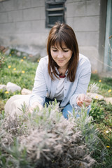 Woman squatting in garden and picking flowers