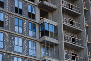 Fototapeta premium Installation of double-glazed windows in a multi-storey building at a construction site. Glazed window systems with uPVC frames. Housing Renovation Program