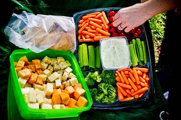 hand reaching for food on a vegetable tray