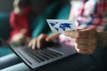 Female hand hold white plastic credit card closeup background. Distance telework concept