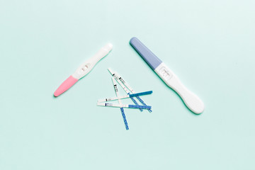 Colored Pregnancy test on colored background, top view with copy space