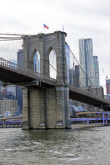 Obraz premium New york, USA - 20.12.2019: Brooklyn bridge in New York, Manhattan skyscrapers skyline behind across Hudson river at end of day New York, USA - stock photo