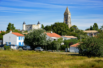 Bell tower church and castle among trees of Noirmoutier en l’Ile in Pays de la Loire, region in western France