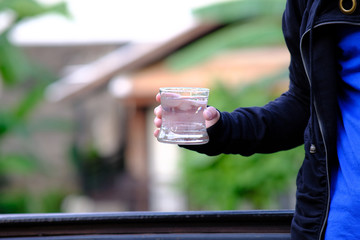Close up pouring purified fresh drink water from the bottle on wood counter and space for text