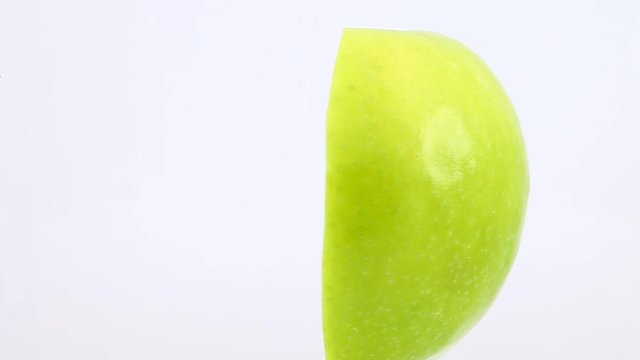 Half apple core one vertically rotate, side view, spinning slowly in a circle, close up.