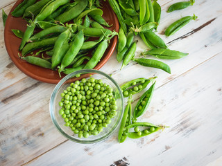 top view of fresh peas on a bowl, isolated on a wooden table