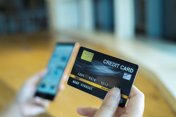 Woman use smart phone and holding credit card with shopping online.