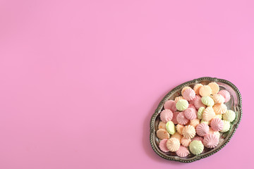 silver tray with meringues on a pink background
