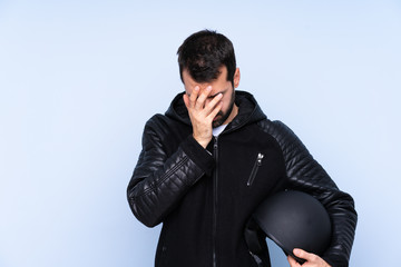 Man with a motorcycle helmet over isolated background with tired and sick expression