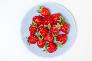 Fresh strawberry on plate. Top view blue plate with red strawberries.