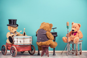 Teddy Bear toys music band trio: vocalist with retro old microphone, bear in cylinder hat playing...